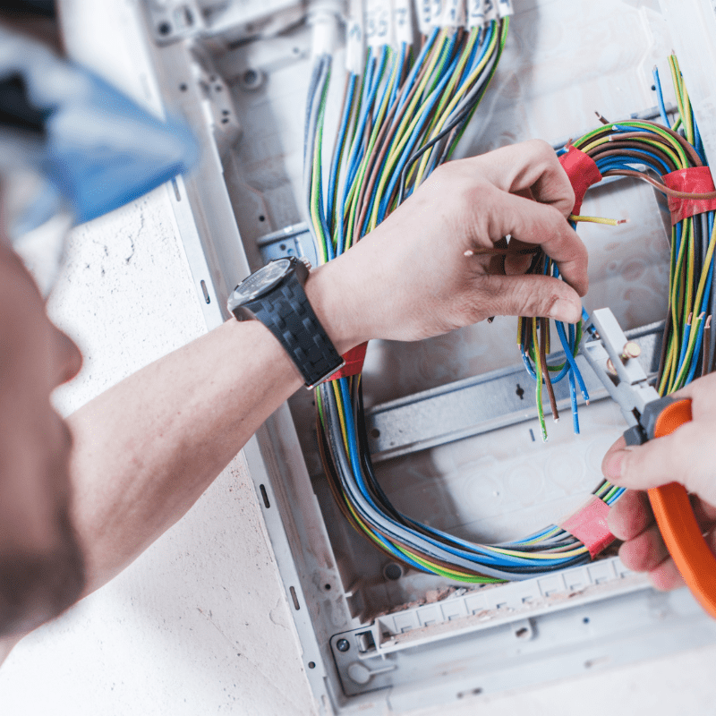 Instalador eléctrico profesional pelando cables para acabar la instalación
